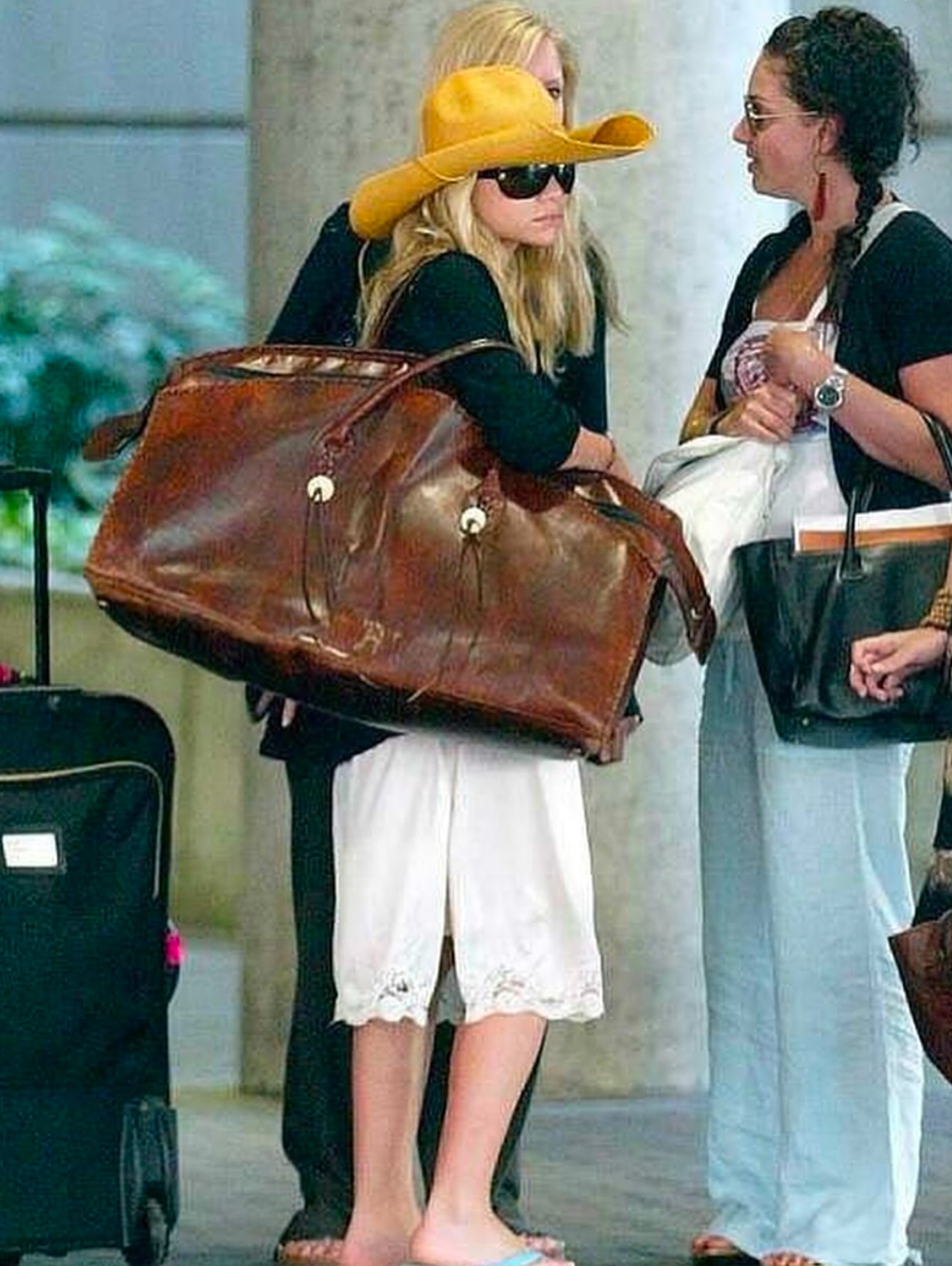 Ashley Olsen with an oversized rodeo duffle bag and XL cowboy hat